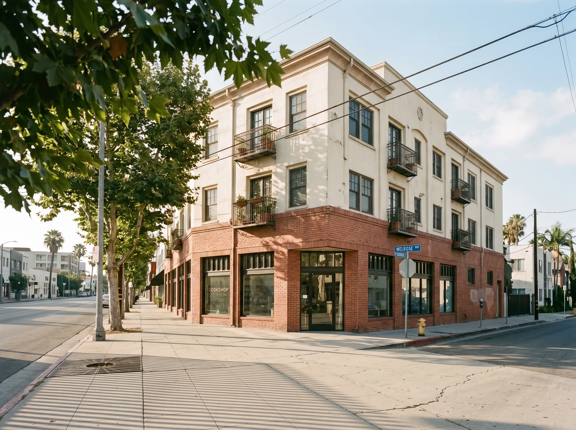Adaptive-reuse corner commercial building with brick ground floor and stucco apartments above.